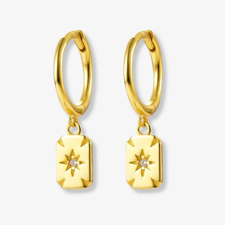 Gold plated rectangle drop earrings, potentially Bohomoon style, featuring small gold hoops with dangling rectangular charms, each with a central starburst design and a sparkling crystal. These modern earrings are available in Ottawa, Ontario, Canada.