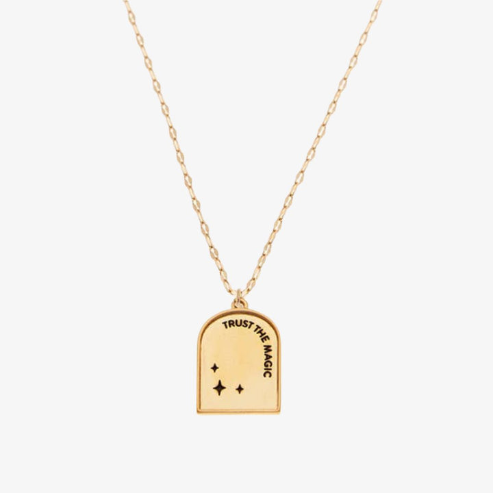 A gold necklace with a pendant shaped like an archway. The pendant has the words 