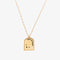 A gold necklace with a pendant shaped like an archway. The pendant has the words 