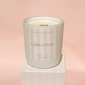 Candle with 'North & Rose Golden Hour' label on a pink background