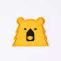 Yellow bear-shaped patch with a black face on a white background