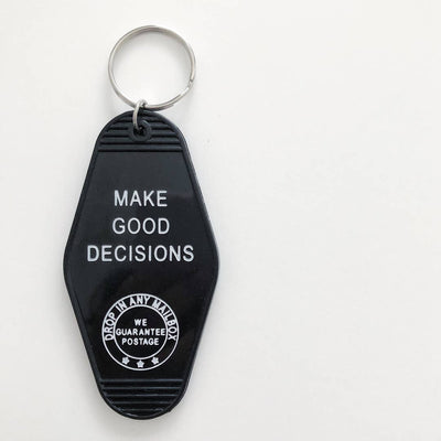 A black, motel-style key tag with a silver keyring. The white text on the tag reads 
