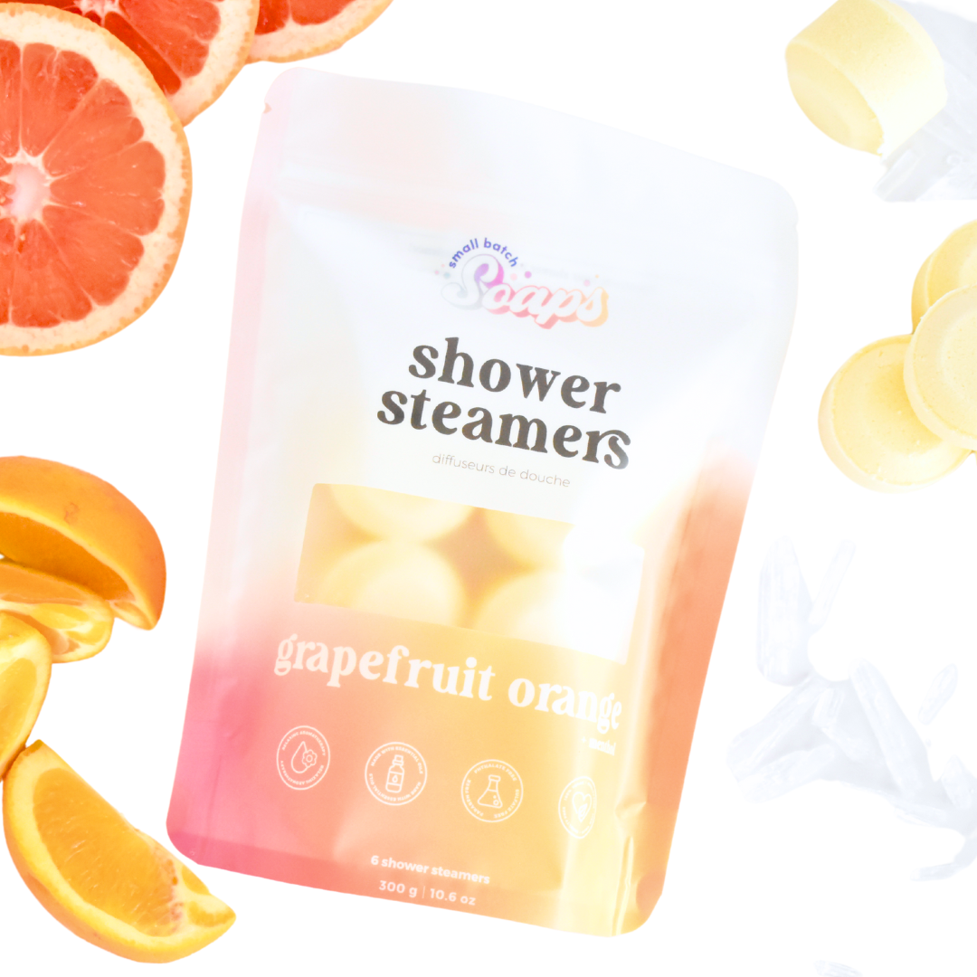 Grapefruit orange shower steamers with packaging and fruit slices on a white background