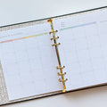 A black agenda with the phrase "It's Gonna Be A Great Year" written in colorful letters. The letters are outlined in gold and there are gold stars scattered around the text. The agenda has a purple elastic band.