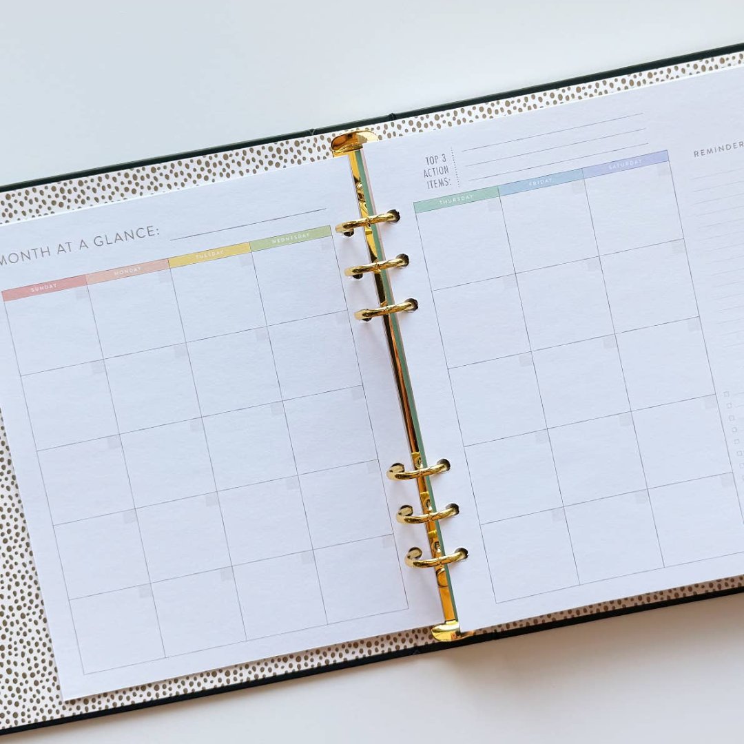 A black agenda with the phrase "It's Gonna Be A Great Year" written in colorful letters. The letters are outlined in gold and there are gold stars scattered around the text. The agenda has a purple elastic band.