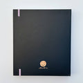 A black agenda with the phrase "It's Gonna Be A Great Year" written in colorful letters. The letters are outlined in gold and there are gold stars scattered around the text. The agenda has a purple elastic band.