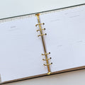 A black agenda with the phrase "It's Gonna Be A Great Year" written in colorful letters. The letters are outlined in gold and there are gold stars scattered around the text. The agenda has a purple elastic band.