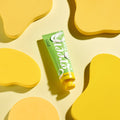 Green hand lotion tube on a yellow background