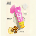 Pink Me Up Lip & Cheek Tinted Balm, a liquid blush that can be used for your eyes, cheeks and lips, in a colourful squeeze tube, next to a small pile of peptides, botanical oil and shea nuts and butter.