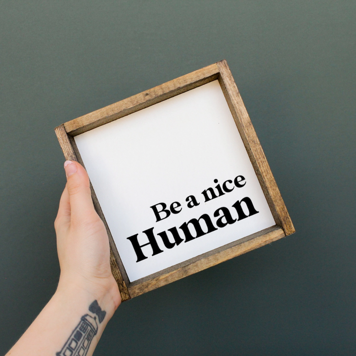 A framed square wooden sign with the text 