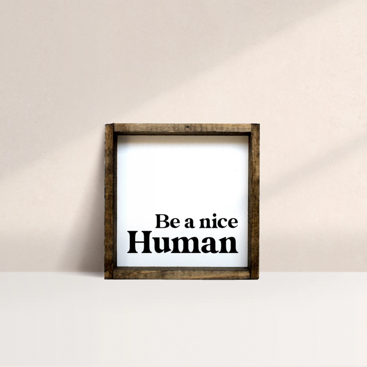 A framed square wooden sign with the text 