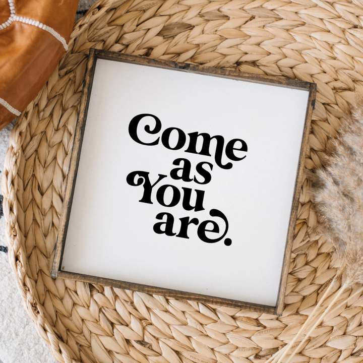 A framed square wood sign with the text 