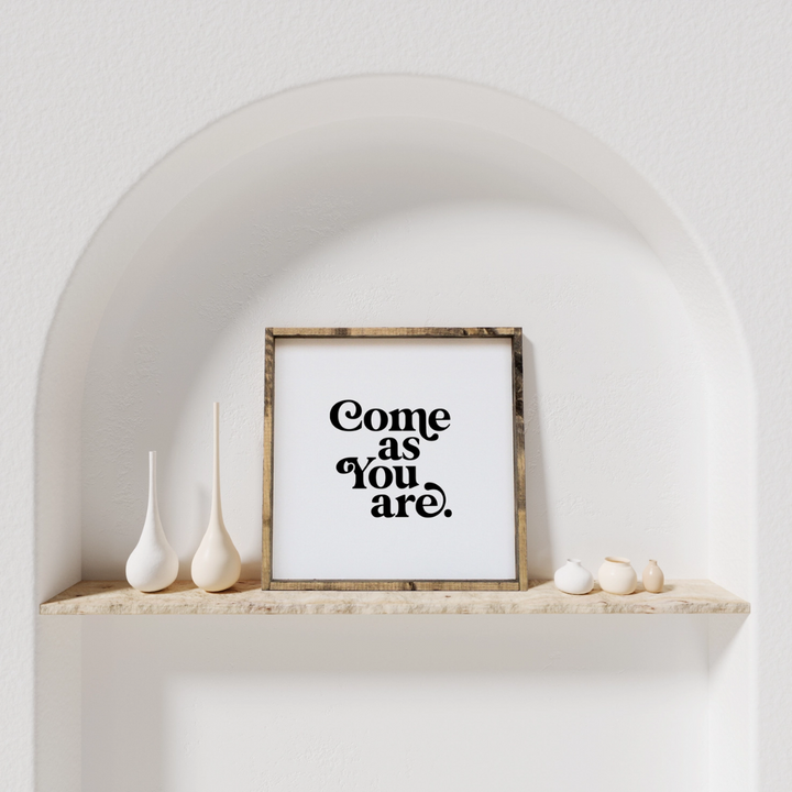 A framed square wood sign with the text 