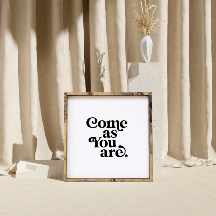 A framed square wood sign with the text 