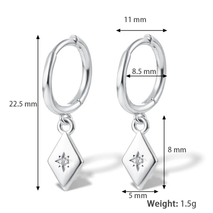 White gold plated diamond drop earrings featuring small hoops with dangling rhombus-shaped charms, each with a central sparkling crystal resembling a North Star. These elegant earrings are available in Ottawa, Ontario, Canada.