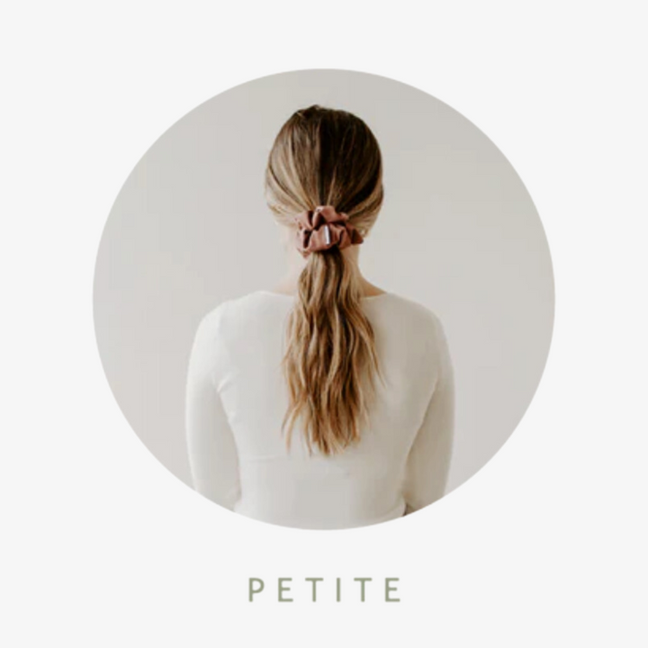 A size guide of the petite sized scrunchie exampled in a person's hair.