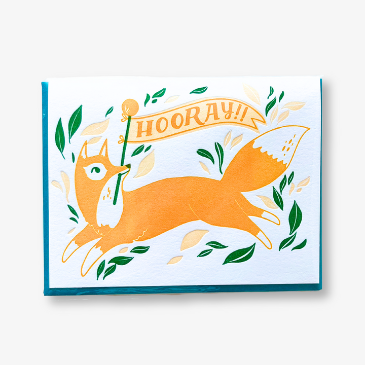 Hooray Fox Congratulations Card, a greeting card with an image of a fox holding a banner that says HOORAY!! a card perfect for any celebration.