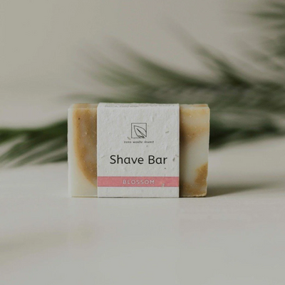 A rectangular bar of shaving soap, wrapped in a paper band with the text 