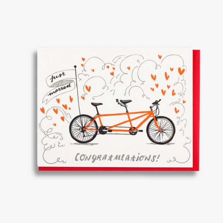 Tandem Bike Wedding Card, a white greeting card with an image of a tandem bike with a flag on the back tire reading 