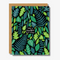 Colourful birthday card with a vibrant pattern of various green and blue leaves on a black background. In the center, white text reads 'Have a beautiful birthday!' The card is bordered by a kraft paper edge, adding a natural and earthy touch.
