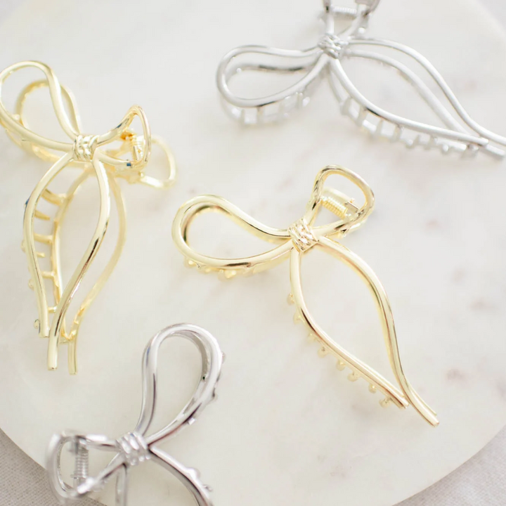 Gold and Silver Metallic Bow Clip, a claw clip in a metallic finish. Perfect for adding a feminine touch to any hairstyle.