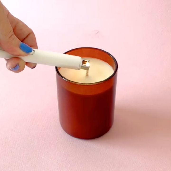 A DuoTone Flameless Lighter being used to light a candle.