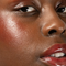 Red-dy or Not Lip & Cheek Tinted Balm, a liquid blush used on a black woman's eyes, cheeks and lips.