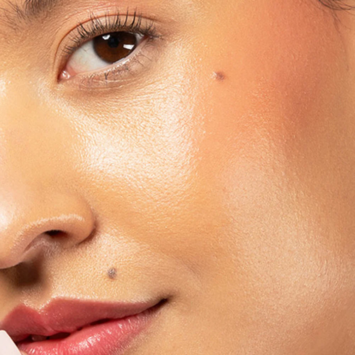 Red-dy or Not Lip & Cheek Tinted Balm, a liquid blush used on a woman with medium skin tone's  eyes, cheeks and lips.