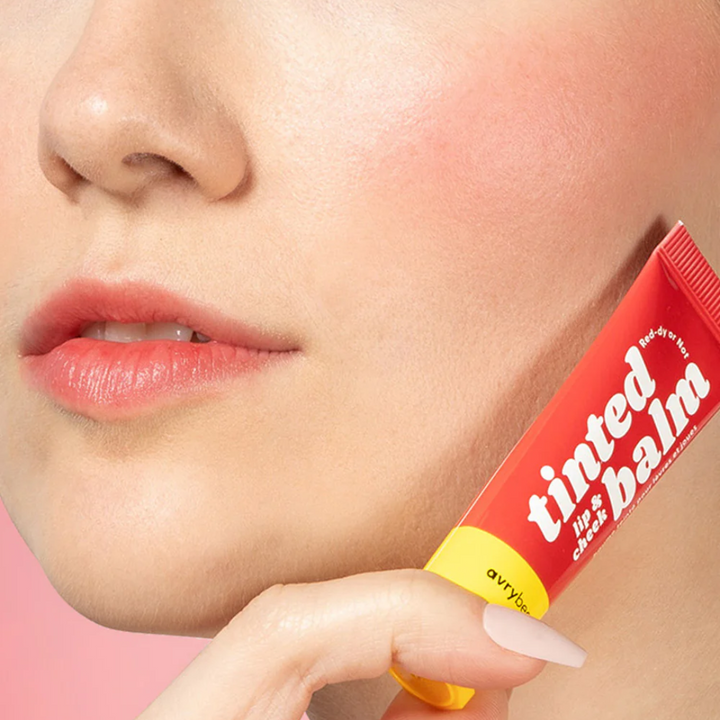 Red-dy or Not Lip & Cheek Tinted Balm, a liquid blush used on a white woman's eyes, cheeks and lips.