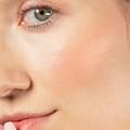 Red-dy or Not Lip & Cheek Tinted Balm, a liquid blush used on a white woman's eyes, cheeks and lips.