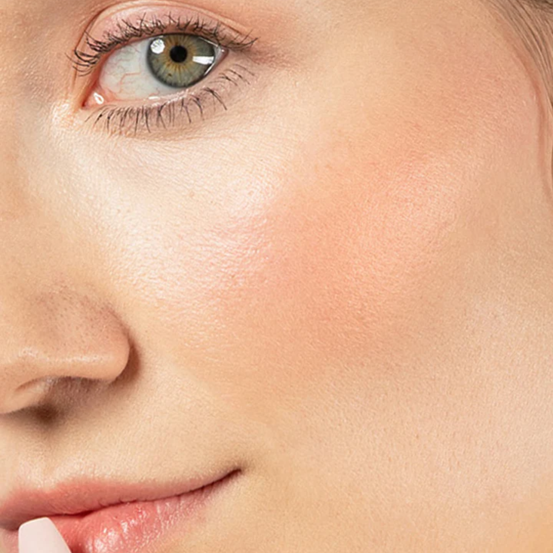 Red-dy or Not Lip & Cheek Tinted Balm, a liquid blush used on a white woman's eyes, cheeks and lips.