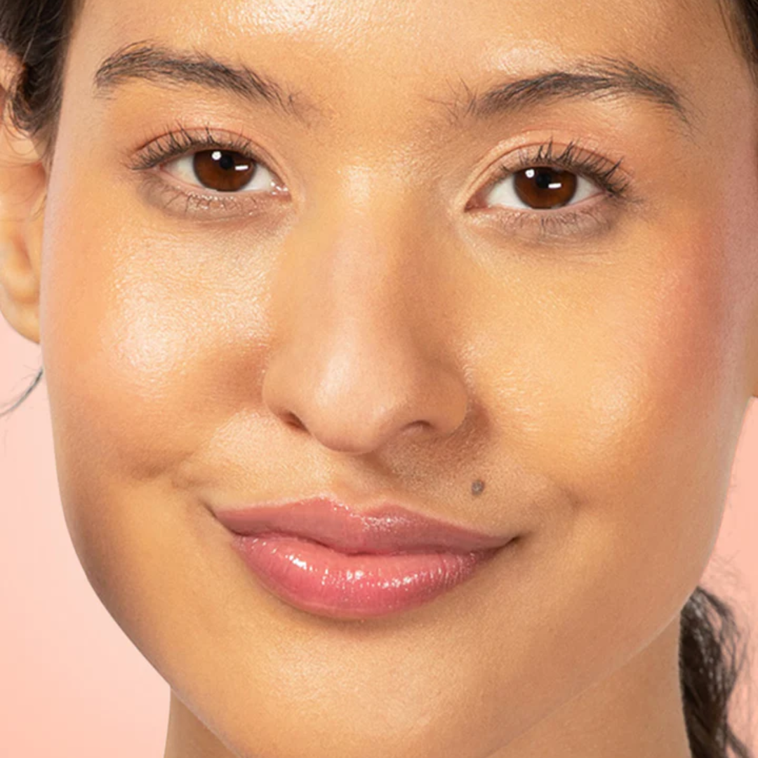 Red-dy or Not Lip & Cheek Tinted Balm, a liquid blush used on a medium skin toned woman's eyes, cheeks and lips.