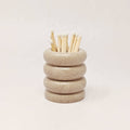 Stacked ceramic rings with wooden sticks on a light background