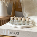 Set of small glass bottles with wooden caps on a decorative tray