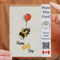 Seeded paper card with bee design and balloons, held by a person.