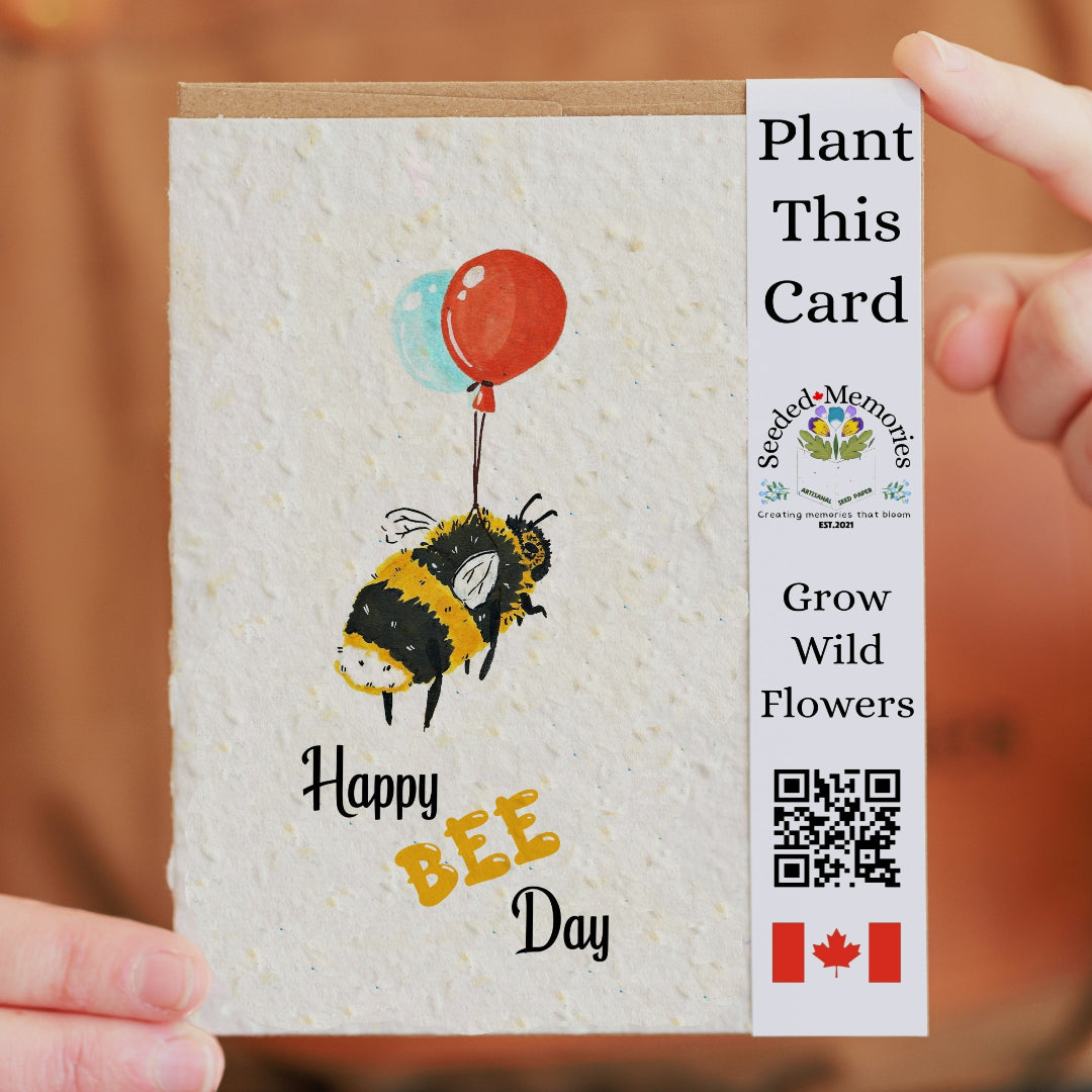 Seeded paper card with bee design and balloons, held by a person.