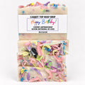 Three stacked bars of artisanal soap with a white paper label reading 'CARROT TOP SOAP SHOP Happy Birthday! Luxury Artisan Soap'. The soap is creamy off-white with colorful curly shavings and multicolored flecks throughout, photographed on a clean white background.
