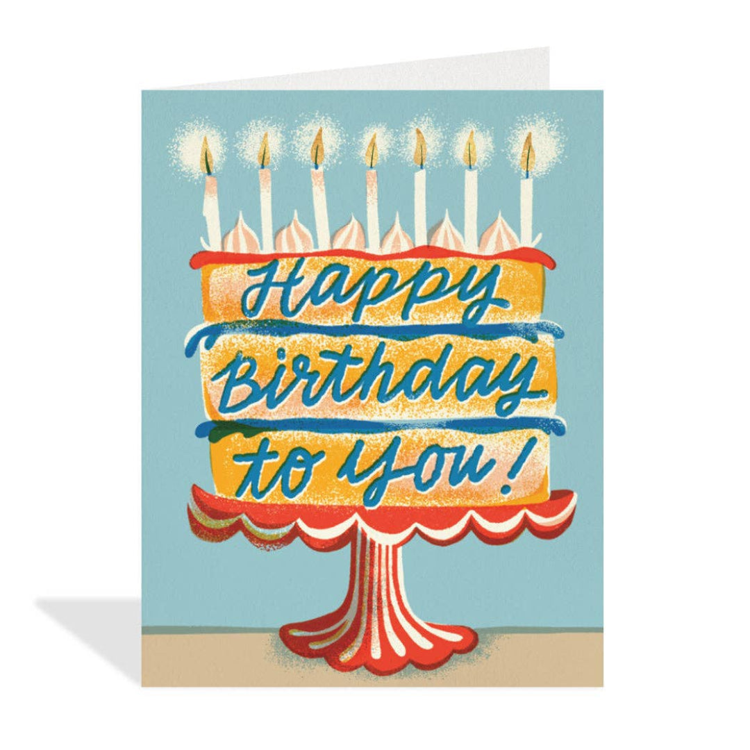 Birthday card with a cake illustration and 'Happy Birthday to you!' text on a blue background.