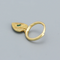 Gold mini hoop earrings featuring dangling heart charms, each with a central marquise-cut green crystal and radiating etched lines. These dainty and elegant earrings are available in Ottawa, Ontario, Canada.