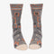 A pair of grey men's crew socks with orange, white, and black abstract lines. One sock features a cartoon drawing of a man with an orange background and the text 