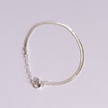 Silver bracelet with small stones on a light gray background