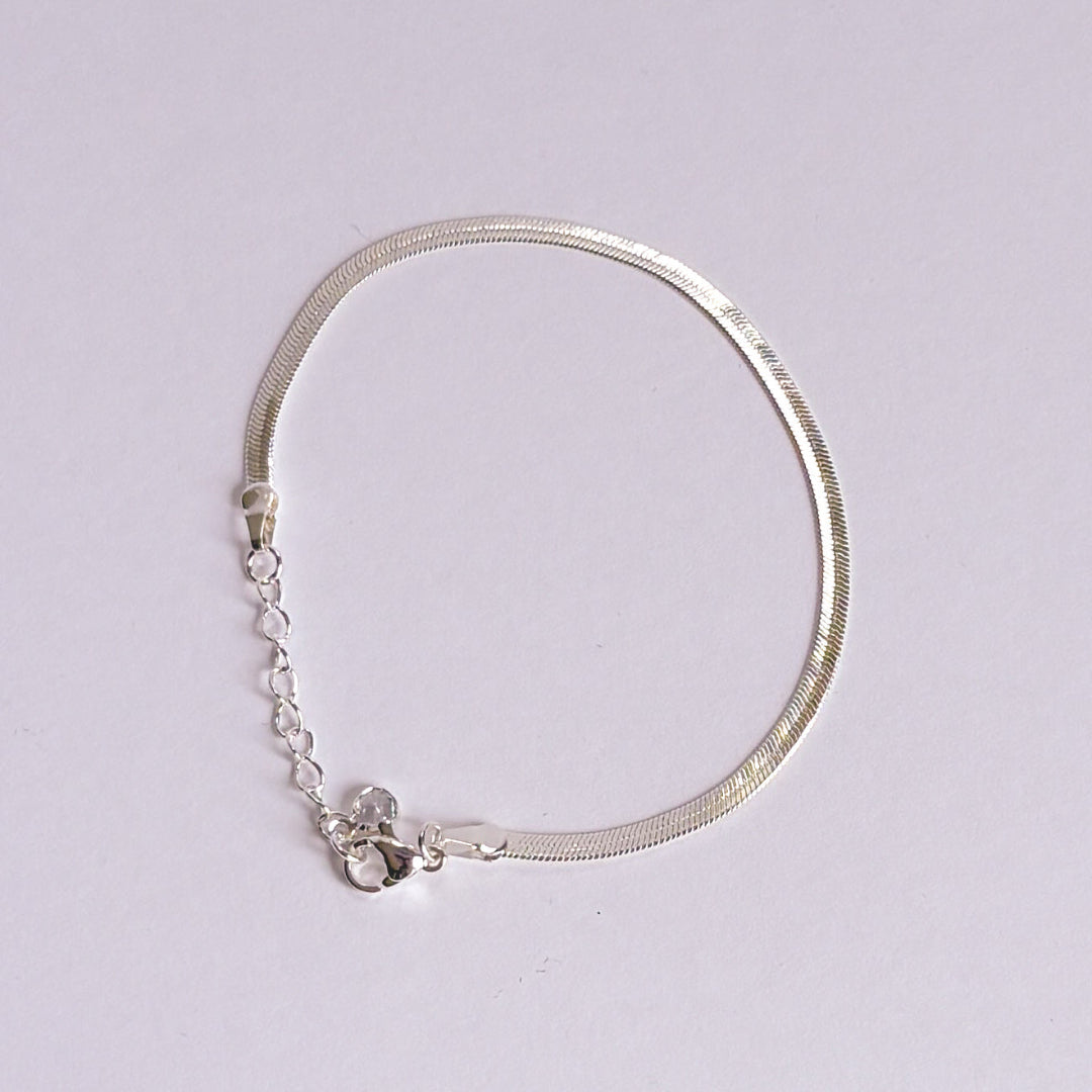 Silver bracelet with small stones on a light gray background