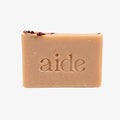 Bar of soap with 'aide' branding on a light gray background