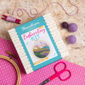 Embroidery kit with hoop, scissors, and thread on a textured surface