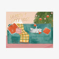 Christmas-themed card with a dog on a couch, gift, and tree.