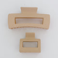 Two beige hair clips on a white background
