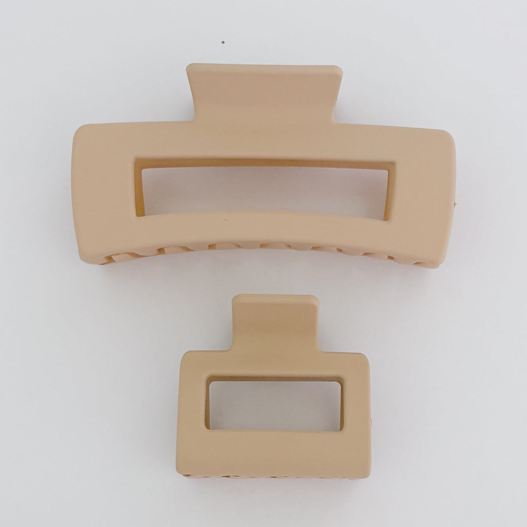 Two beige hair clips on a white background