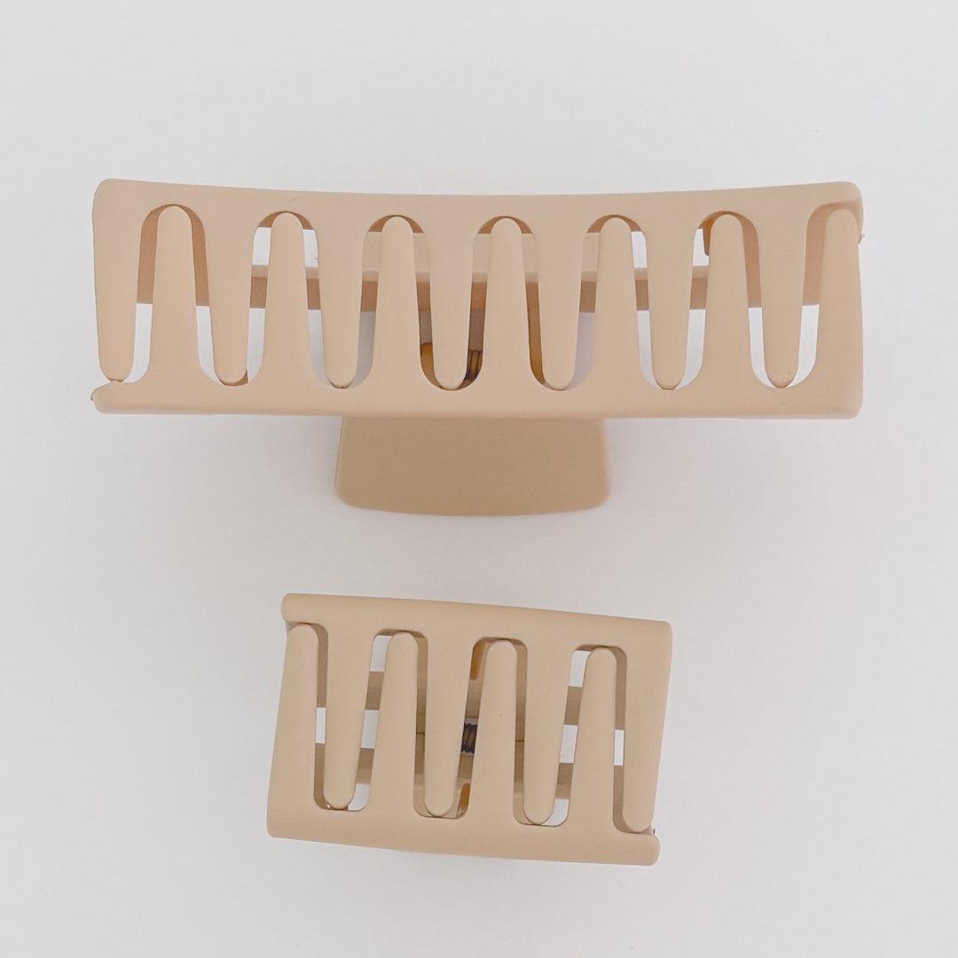 Two beige hair clips on a white background