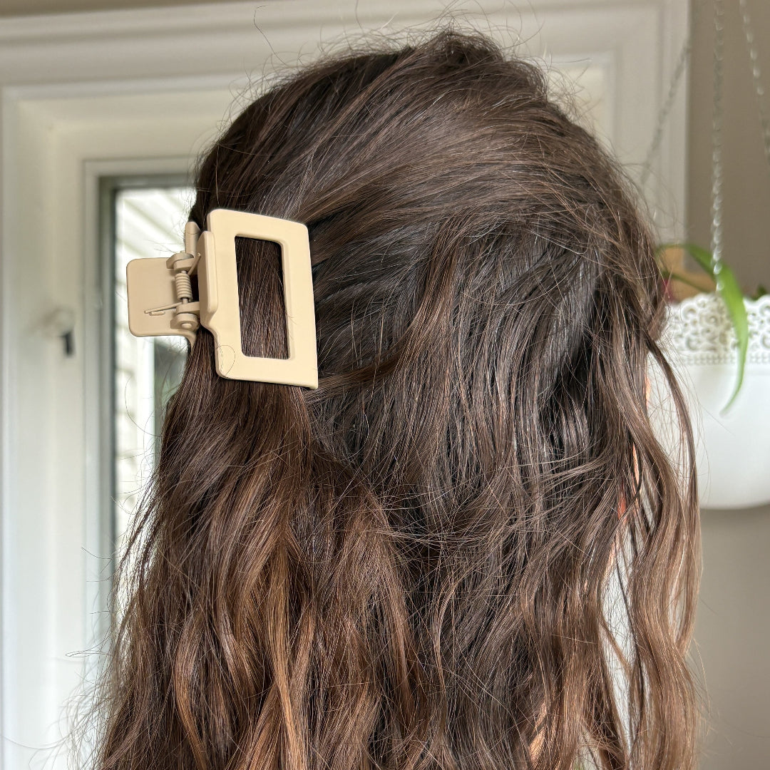 Close-up of a person's hair with a gold hair clip, indoor setting