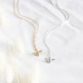 Two bee-shaped pendants on gold and silver necklaces against a white background